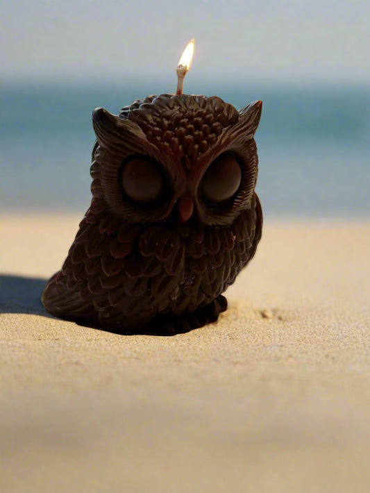 Owl-shaped candle with a lit wick 