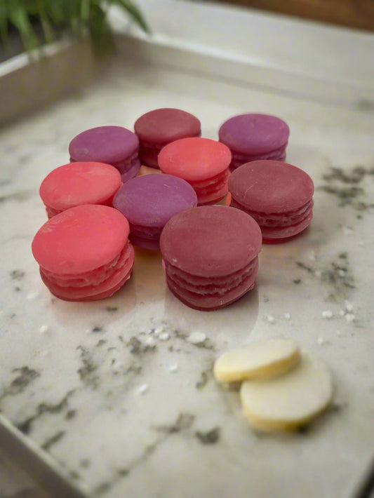 Pink and purple macaron cookies on a white surface